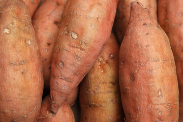 Whole ripe sweet potatoes as background, top view