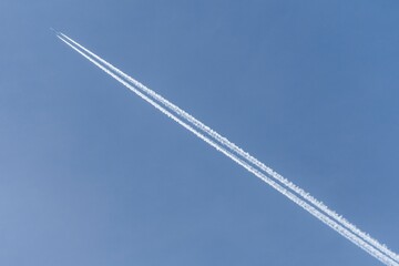 Airplane in the sky with contrails