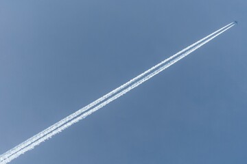 Airplane in the sky with contrails