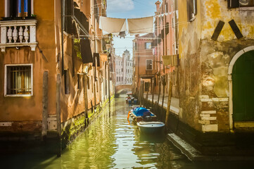 Small canal with clothes hung over the canal, with moored boats, old houses and Venetian lagoon, Venice, UNESCO world heritage site, Veneto, Italy, Europe.