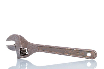One old metal adjustable wrench, close-up, isolated on white.