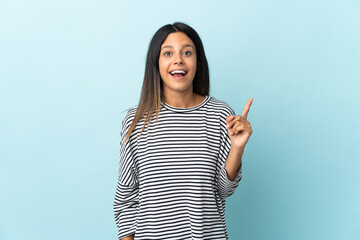 Caucasian girl isolated on blue background intending to realizes the solution while lifting a finger up