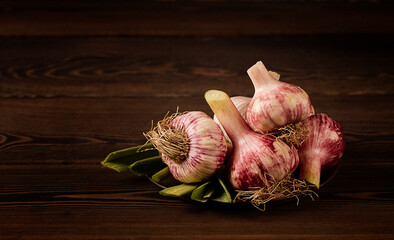 Fresh, young garlic with leaves, on a wooden table, rustic, horizontal, no people,