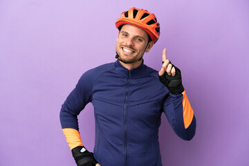 Young Brazilian cyclist man isolated on purple background showing and lifting a finger in sign of the best - obrazy, fototapety, plakaty