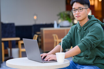 カフェでパソコン作業をする若者