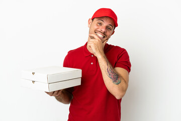 pizza delivery man with work uniform picking up pizza boxes over isolated  white wall happy and...