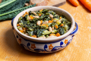 Black cabbage and bean soup on a wooden background Excellent for a healthy and vegan dinner.