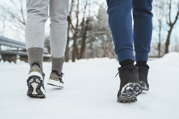Two joggers feet during winter jogging in snowy city park