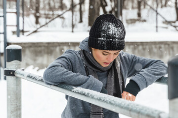 Athletic woman during her winter outdoor workout on parallel bars