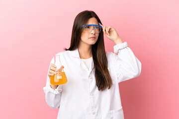 Young scientific girl over isolated pink background having doubts and thinking