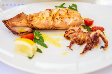 Grilled squid with lemon and cherry tomatoes in Thassos, Greece