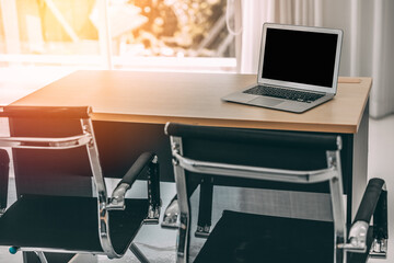 An office room with orange light coming through the window at sunset