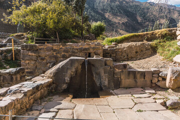 Baños de la ñusta water fountain in the archaeological center of Ollantaytambo in a sunny day surrounded by green trees in the Sacred Valley of the Incas Peru