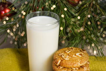 treats for santa claus. round cookies with nuts and milk on the background of the Christmas tree