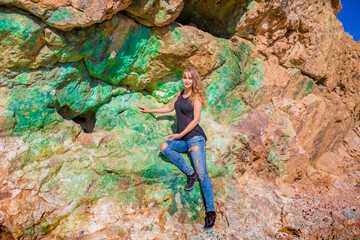 Girl in a cave with semi-precious stones in a natural environment. The wall in the gallery is made...