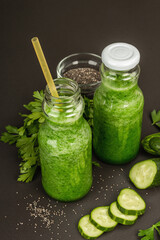 Green smoothie with cucumber in glass bottles. Fresh ripe vegetables, greens, and chia seeds