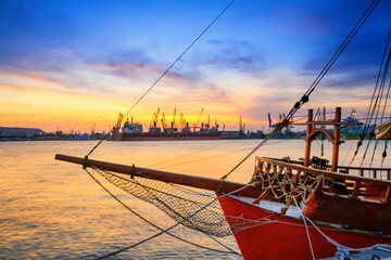 View of the port of Varna at sunset, moored sailing ship and harbor cranes in the background, on the Black Sea coast of Bulgaria