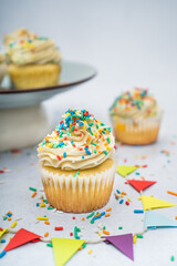 cupcakes with sprinkles on a plate decorated for a birthday