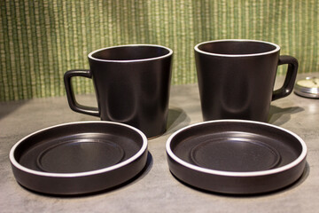 Two cups and saucers on a neutral background