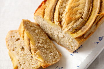 homemade banana bread on a wooden board on a table with a tablecloth