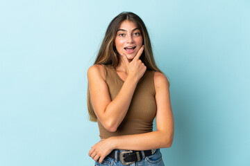 Young caucasian woman isolated on blue background happy and smiling