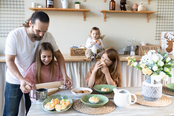 A family with three children has fun baking together.Dad And Daughter Laughing And Cooking Healthy Food Front View Lifestyle Concept . Candid