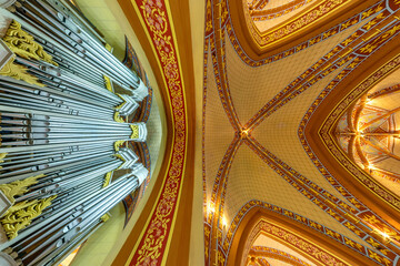 interior dome and looking up into a old gothic catholic  church ceiling with pipe organ