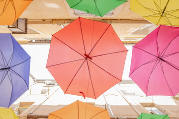 Parapluies suspendus dans une rue.	