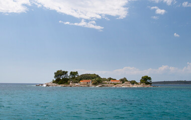 A small lonely island with a house and a dock in the sea