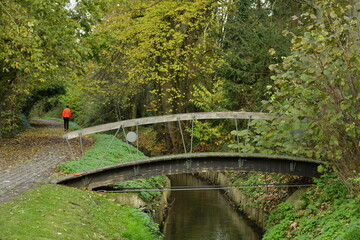 Petit pont arqué au dessus les eaux cristallines de la Woluwe en automne à Woluwe-St-Lambert 