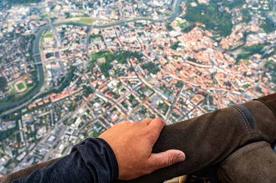 Holding hand on handrail of flying hot air balloon basket during the scenic flight above famous Old Town of Vilnius capital of Lithuania