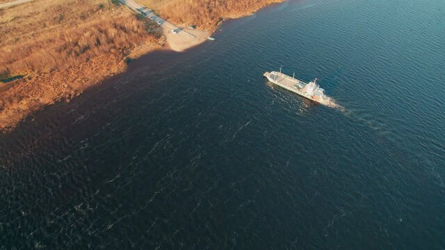 Shot on a drone. Ferry crossing the river. The view from the drone. Passenger and transport communication. Water transport.