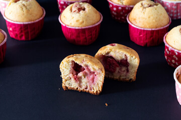 Muffins with cherries and strawberries on a black background