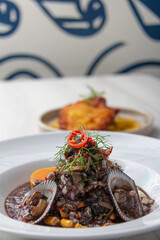 Black ceviche with shell, very typical in Peru. on white plate.
