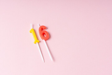 Festive number 16 candles. Pink background. Space for text. Teen's birthday
