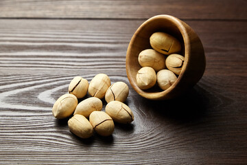 Pecan nuts in bowl on wooden table