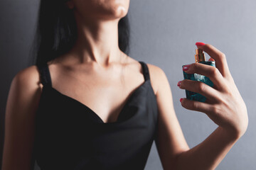 woman sprinkles perfume on her neck