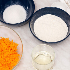 Ingredients for making carrot cake: grated carrots, flour, sugar, vegetable oil