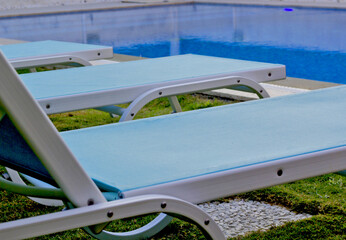 Obraz premium chaise lounge on the pool in the green garden in a resort