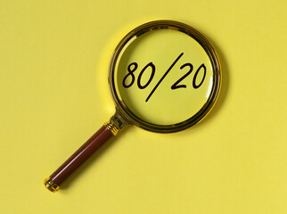 80 20 pareto principle concept, text through magnifying glass on yellow background. - obrazy, fototapety, plakaty