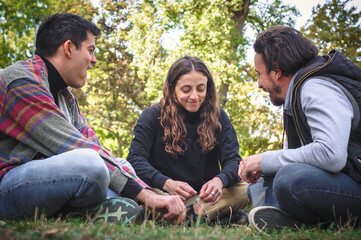 Group of three smiling friends enjoy hanging out together