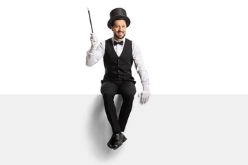 Magician sitting on a blank panel and holding a magic wand
