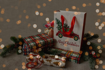 Christmas gifts among spruce branches with beautiful bokeh. Christmas card, flyer, layout design