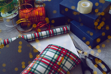 Boxes with gifts among the packaging material, the image is decorated with a beautiful gold bokeh. Christmas, New Year banner, cover, flyer, layout design