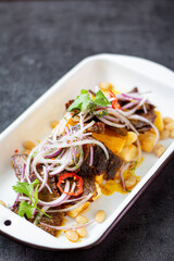 Dry meat, a typical Peruvian dish, accompanied by yuccas and onion sarsa.

