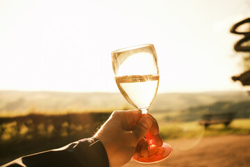 Ein Glas Weißwein im Sonnenuntergang genießen