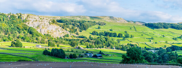 A panorama view over farmland in the River Ribble Valley near Settle, Yorkshire in summertime