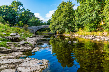Fototapeta na wymiar A view along the River Ribble at the top of the falls at Stainforth Force, Yorkshire in summertime