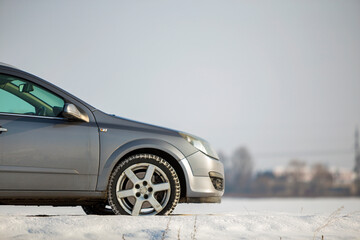 Car parked in snowy field on winter day.