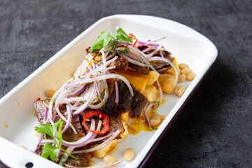 Dry meat, a typical Peruvian dish, accompanied by yuccas and onion sarsa.
